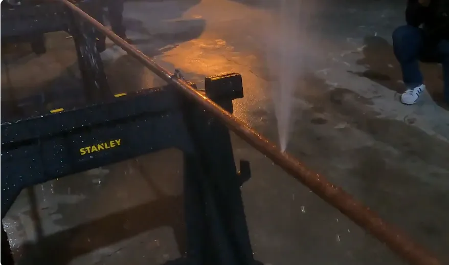 Copper pipe spraying water from a burst